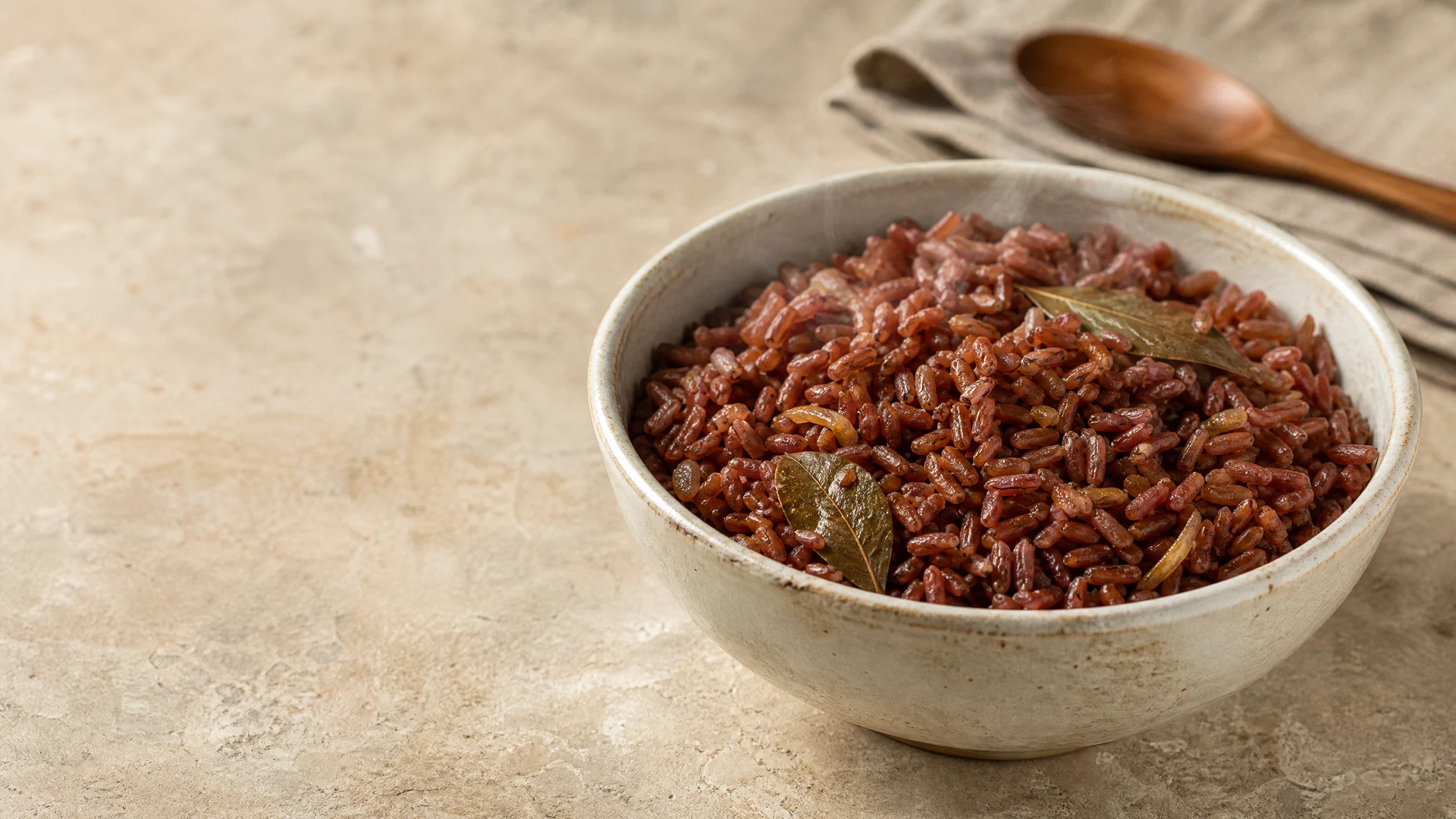 Arroz vermelho cozido e soltinho servido em tigela clara de cerâmica.