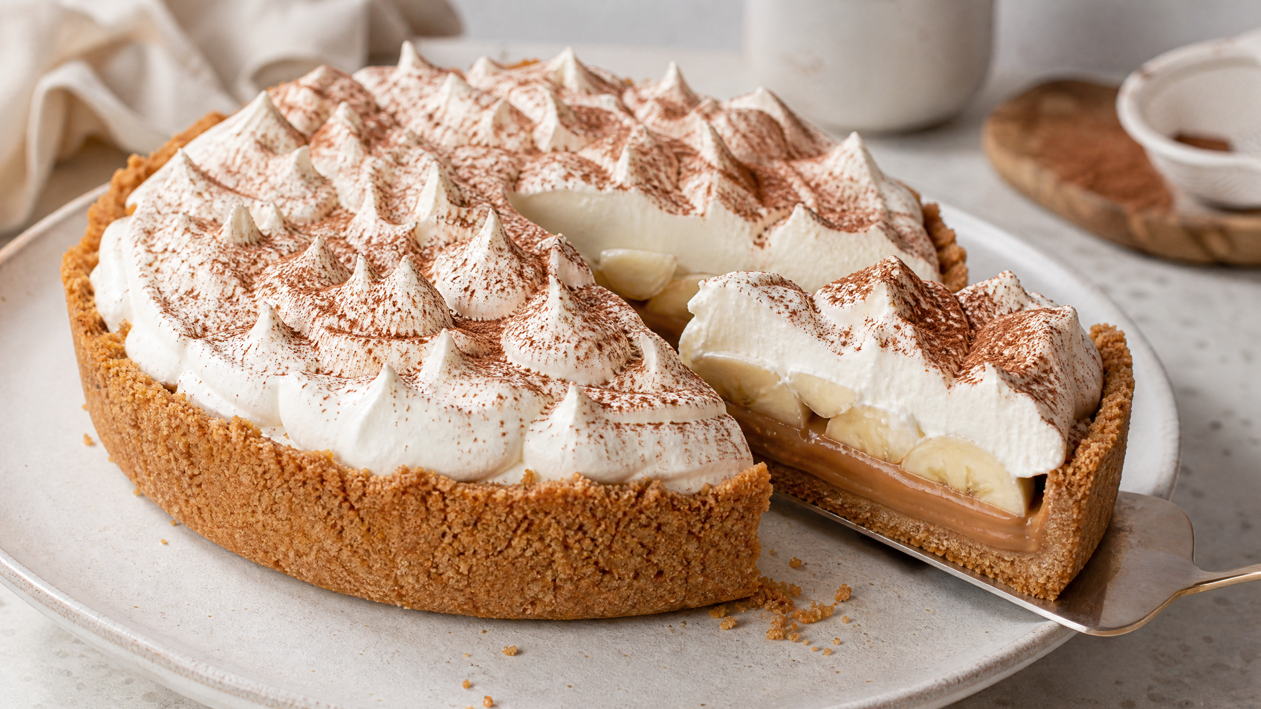 Fatia de banoffee com base crocante, doce de leite, banana e chantilly.