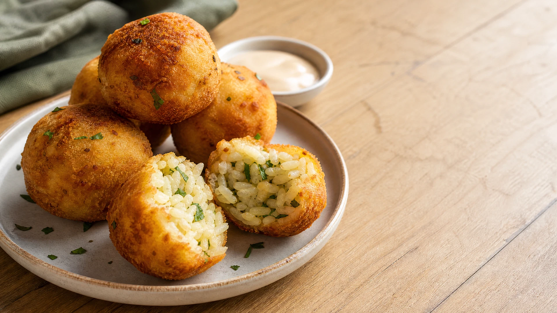Bolinho de arroz sem ovo dourado e aberto em prato com ervas.