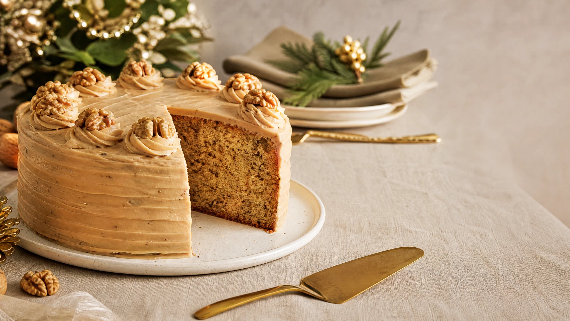 Bolo de nozes com cobertura de doce de leite e fatia mostrando massa úmida.