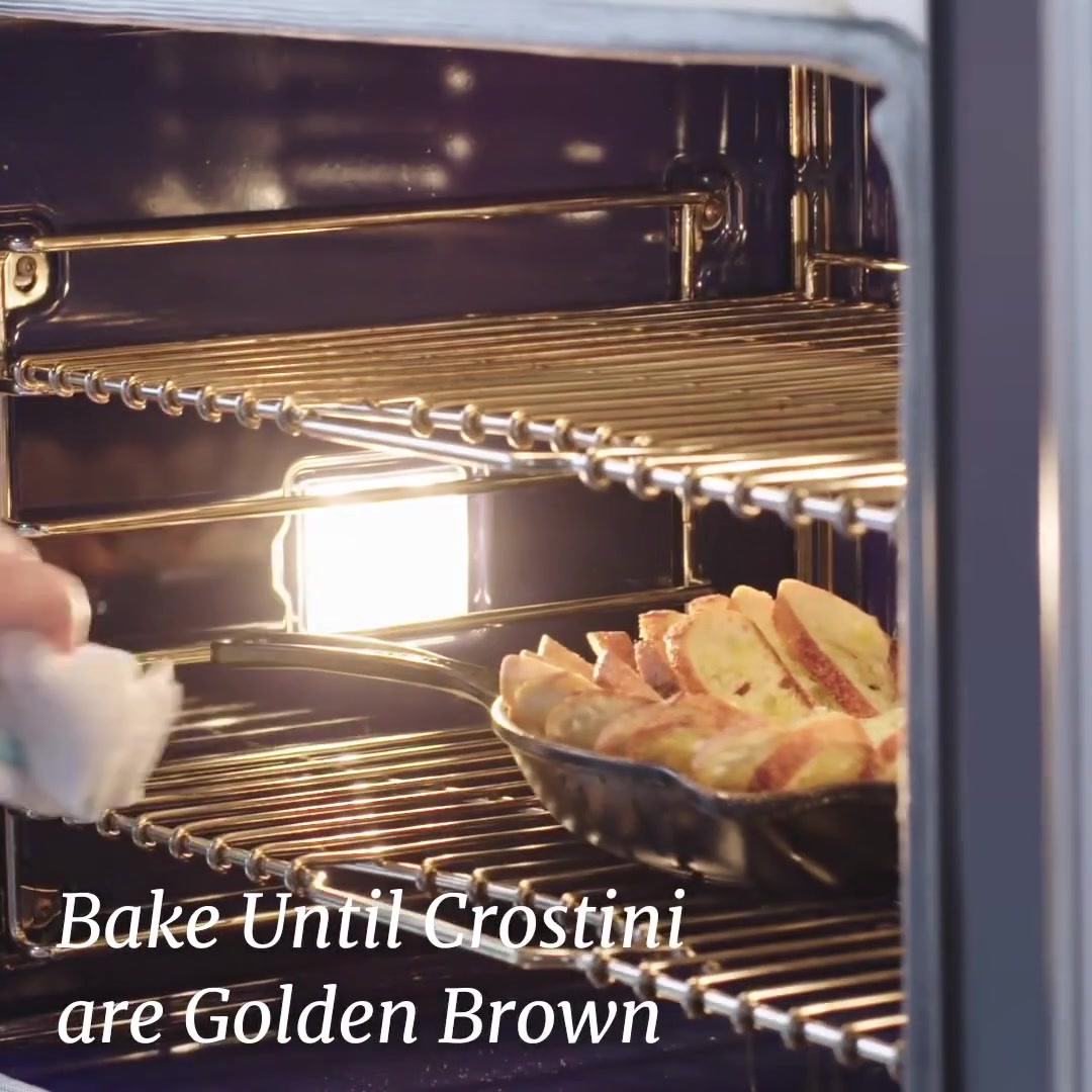 Frigideira com o patê e os crostini sendo levada ao forno