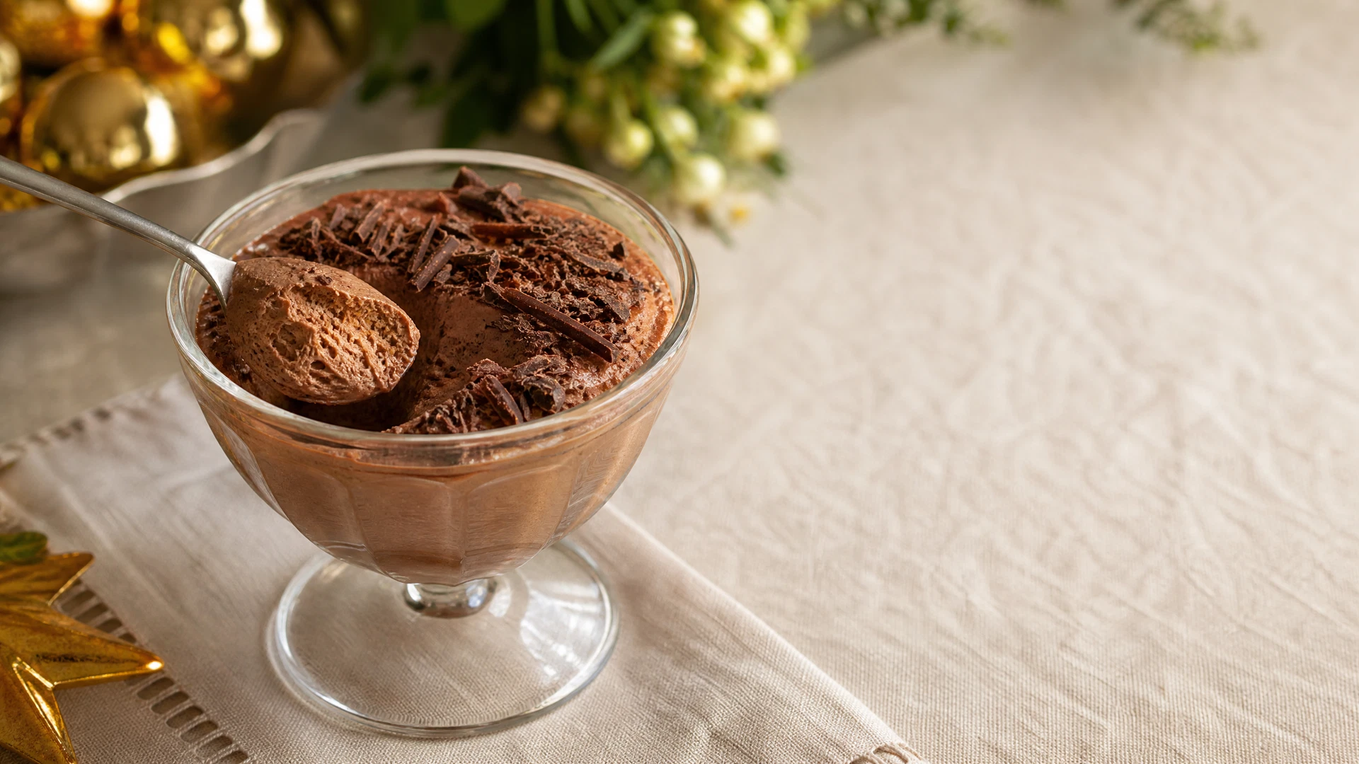 Taça de mousse de chocolate aerada coberta com raspas de chocolate escuro.