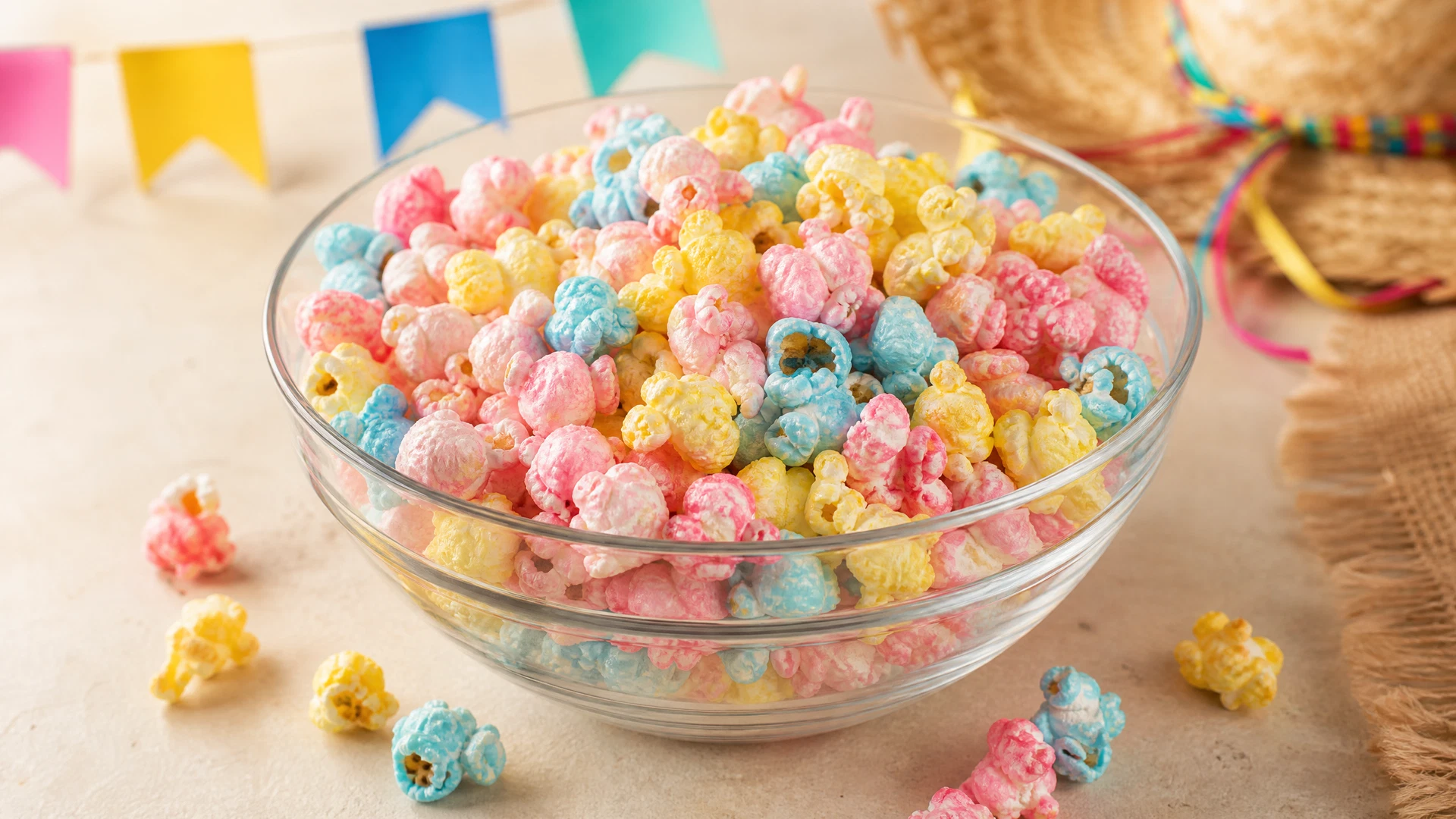 Pipoca doce colorida em tons pastéis servida em tigela de vidro.